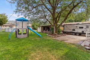 View of grassy yard featuring a playground
