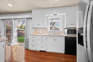 Kitchen with stainless steel appliances, light countertops, white cabinetry, recessed lighting, and a textured ceiling
