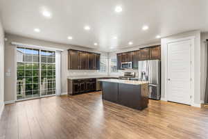 Kitchen with dark brown cabinets, appliances with stainless steel finishes, recessed lighting, a kitchen island, and plenty of natural light
