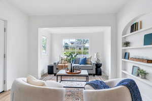 Sitting room featuring built in shelves, plenty of natural light