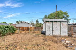 Fenced backyard featuring a shed