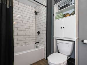 Bathroom with shower / bath combo and wood finished floors