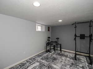 Workout room featuring a textured ceiling and carpet