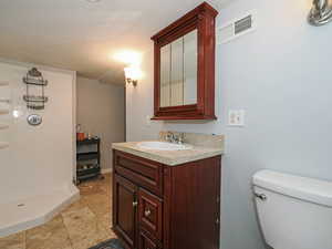 Bathroom featuring vanity, a textured ceiling, and light tile patterned flooring
