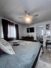 Tiled bedroom featuring ceiling fan and a textured ceiling