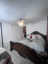 Bedroom featuring tile patterned floors, a closet, ceiling fan, a textured ceiling, and washer / clothes dryer