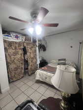 Bedroom featuring light tile patterned flooring, a textured ceiling, and a ceiling fan