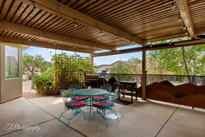 View of patio with outdoor dining area and area for grilling