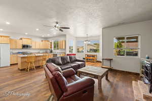 Living area featuring a wood stove, dark wood finished floors, healthy amount of natural light, a textured ceiling, and recessed lighting