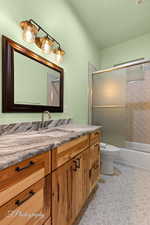 Bathroom featuring vanity, enclosed tub / shower combo, and light tile patterned floors