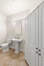 Half bathroom with baseboards and light tile patterned floors