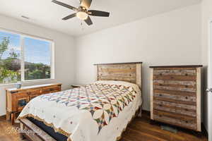 Bedroom with dark wood-style flooring and a ceiling fan