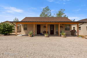 View of front facade featuring stucco siding, roof with shingles, and a patio area