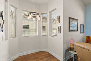 Dining room with dark wood-style floors and a chandelier