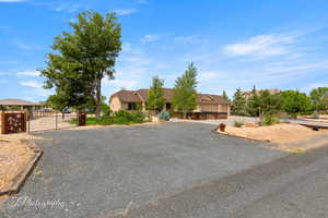 View of front of property featuring gravel driveway and a gate