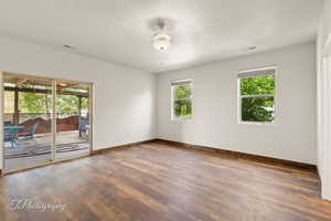 Spare room featuring wood finished floors, a textured ceiling, and a ceiling fan