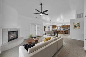 Living area with a tiled fireplace and ceiling fan