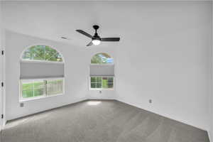Carpeted spare room with baseboards and ceiling fan