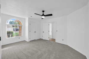 Unfurnished bedroom featuring light colored carpet and ceiling fan