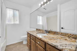 Bathroom with vanity, shower / bath combo with shower curtain, and light tile patterned floors