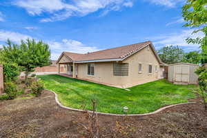 Rear view of house featuring stucco siding, a patio area, a shed, and a tiled roof
