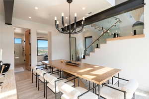 Dining area featuring a chandelier, stairway, light wood-style floors, and recessed lighting