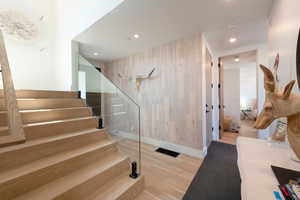 Staircase with recessed lighting, wood finished floors, and wood walls