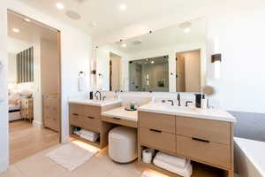 Full bath featuring a shower stall, recessed lighting, ensuite bath, two vanities, and a soaking tub