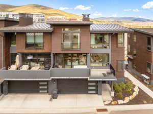 View of front of property with a chimney, a mountain view, a metal roof, and brick siding