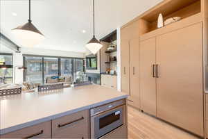 Kitchen featuring open shelves, modern cabinets, pendant lighting, open floor plan, and recessed lighting
