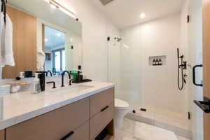 Full bath featuring vanity, a shower stall, recessed lighting, and light tile patterned flooring