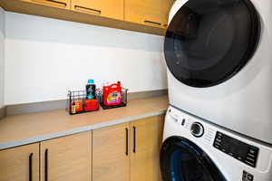 Laundry area featuring cabinet space and estacked washer and dryer