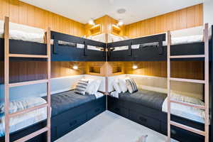 Bedroom featuring wood walls and carpet