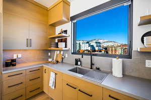 Kitchen featuring open shelves, decorative backsplash, light brown cabinets, a mountain view, and modern cabinets