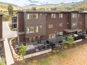 Rear view of property with a chimney, a mountain view, outdoor lounge area, and a patio