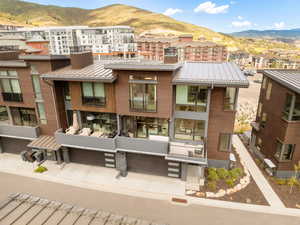 Rear view of house featuring a residential view, a metal roof, a mountain view, and brick siding