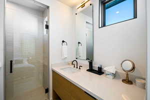 Full bath featuring vanity and a shower stall