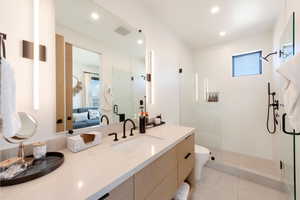Full bathroom featuring a walk in shower, double vanity, connected bathroom, recessed lighting, and light tile patterned floors