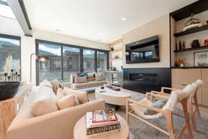Living area with a glass covered fireplace and recessed lighting