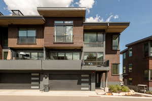 Rear view of house featuring a balcony and a garage