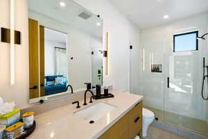 Ensuite bathroom with a shower stall, vanity, and recessed lighting