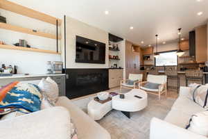 Living area featuring built in features, a glass covered fireplace, and recessed lighting