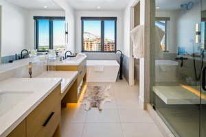 Full bathroom with a shower stall, vanity, a freestanding bath, light tile patterned floors, and recessed lighting