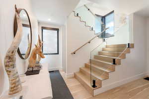 Staircase featuring wood finished floors and recessed lighting