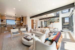 Living area with light wood-type flooring, a chandelier, recessed lighting, and stairs
