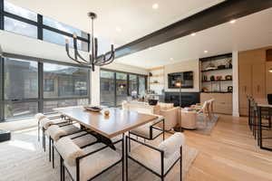 Dining space featuring a chandelier, light wood-style flooring, recessed lighting, and beam ceiling
