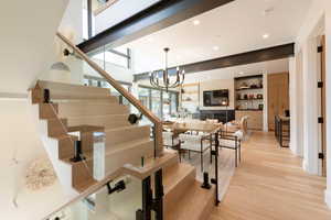 Stairway featuring recessed lighting, a chandelier, and wood finished floors