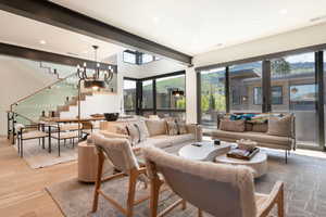 Living room featuring a chandelier, stairway, recessed lighting, and light wood-style floors