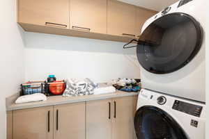 Laundry area with cabinet space and stacked washing machine and dryer