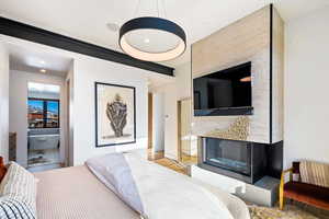 Bedroom with a multi sided fireplace, wood finished floors, and recessed lighting